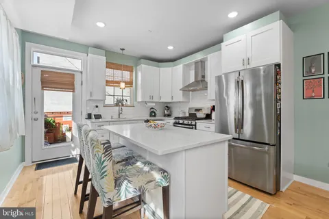 a kitchen with stainless steel appliances granite countertop a refrigerator and a stove top oven