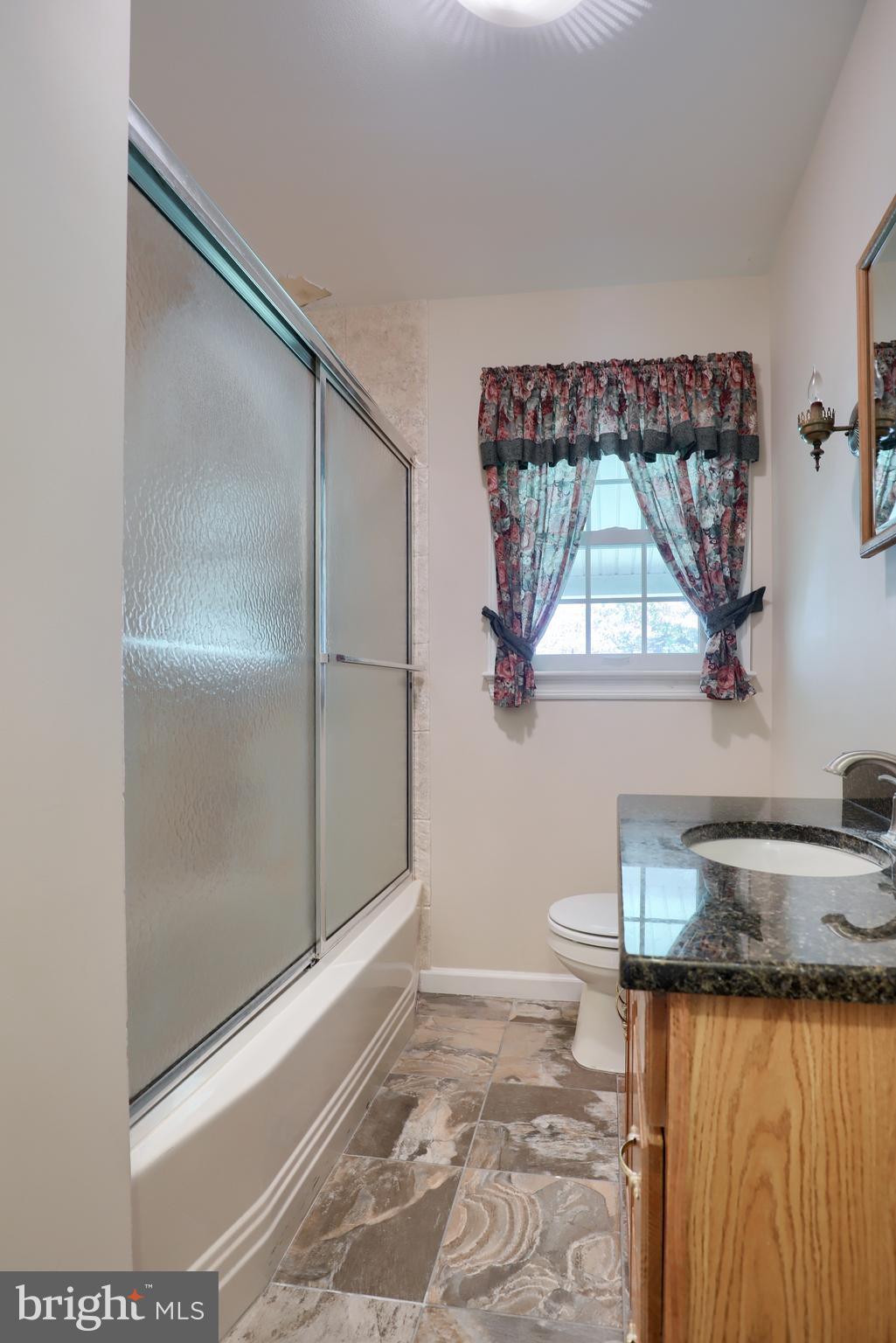 1565 Eden Road Lancaster, PA 17601 - Photo 22 of 33 a bathroom with a granite countertop sink a toilet and a shower
