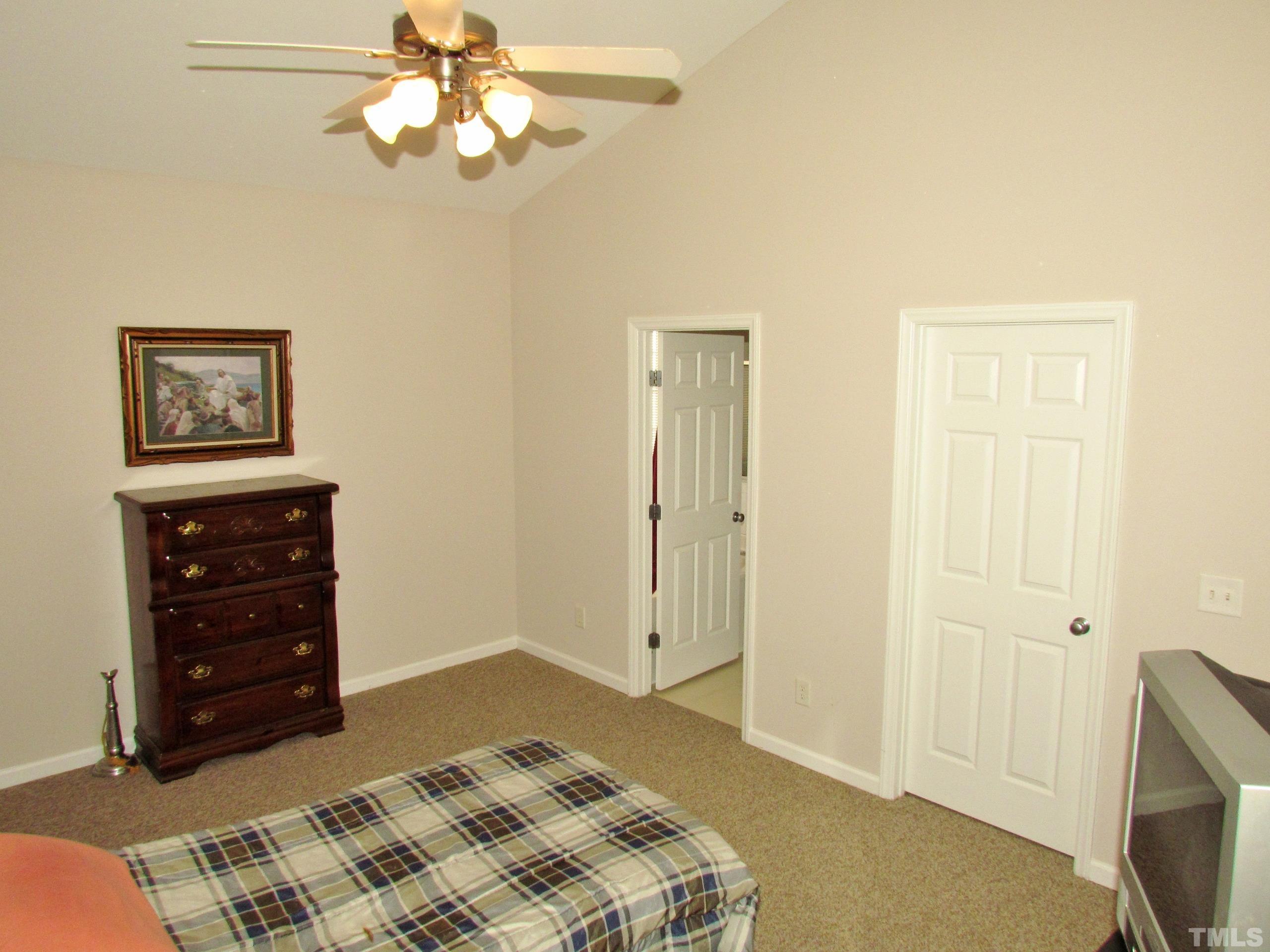 8421 Whisper Ridge Place Raleigh, NC 27613 - Photo 12 of 30 a bedroom with a bed and a television