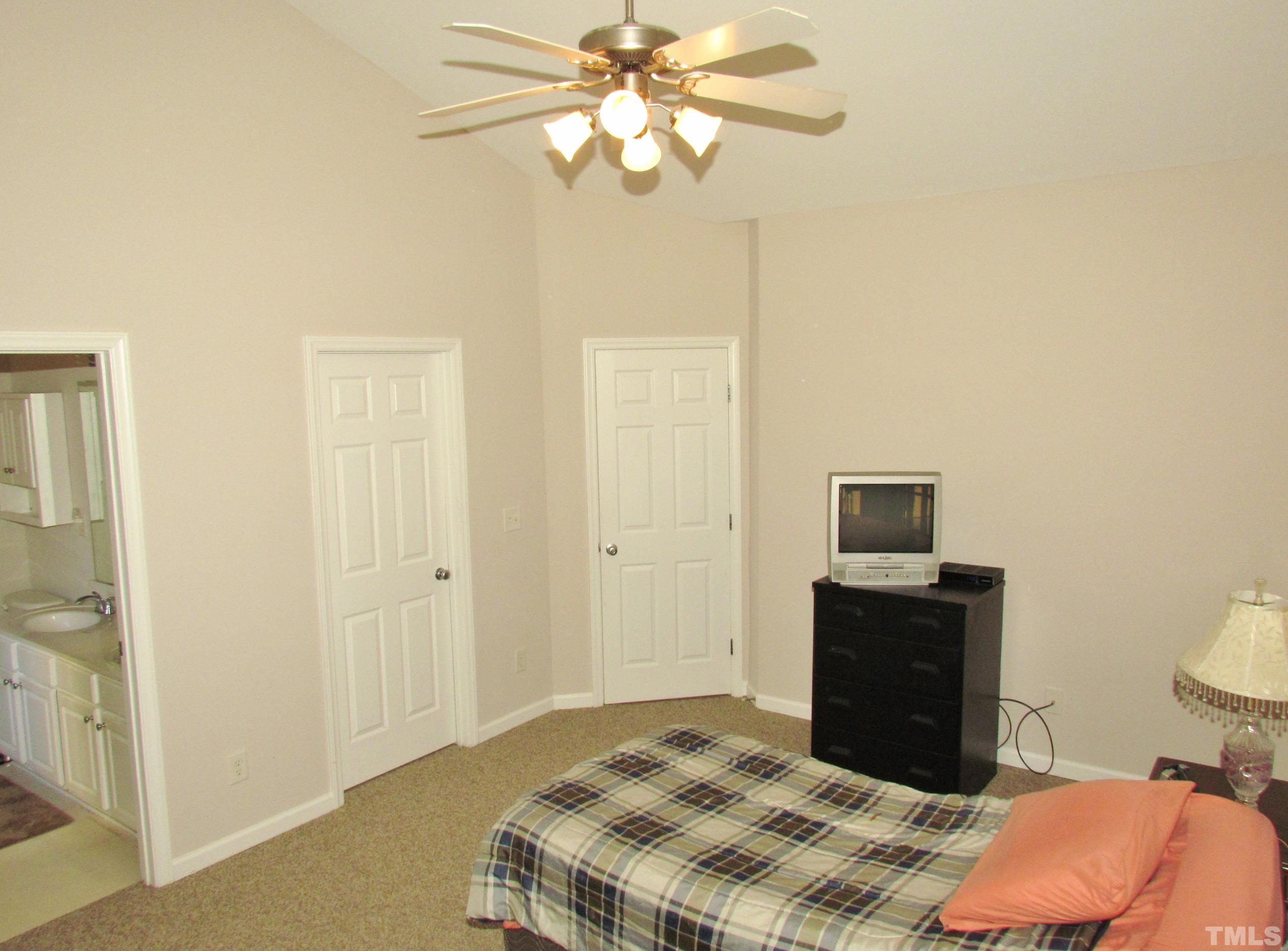 8421 Whisper Ridge Place Raleigh, NC 27613 - Photo 13 of 30 a bedroom with a bed and a chandelier