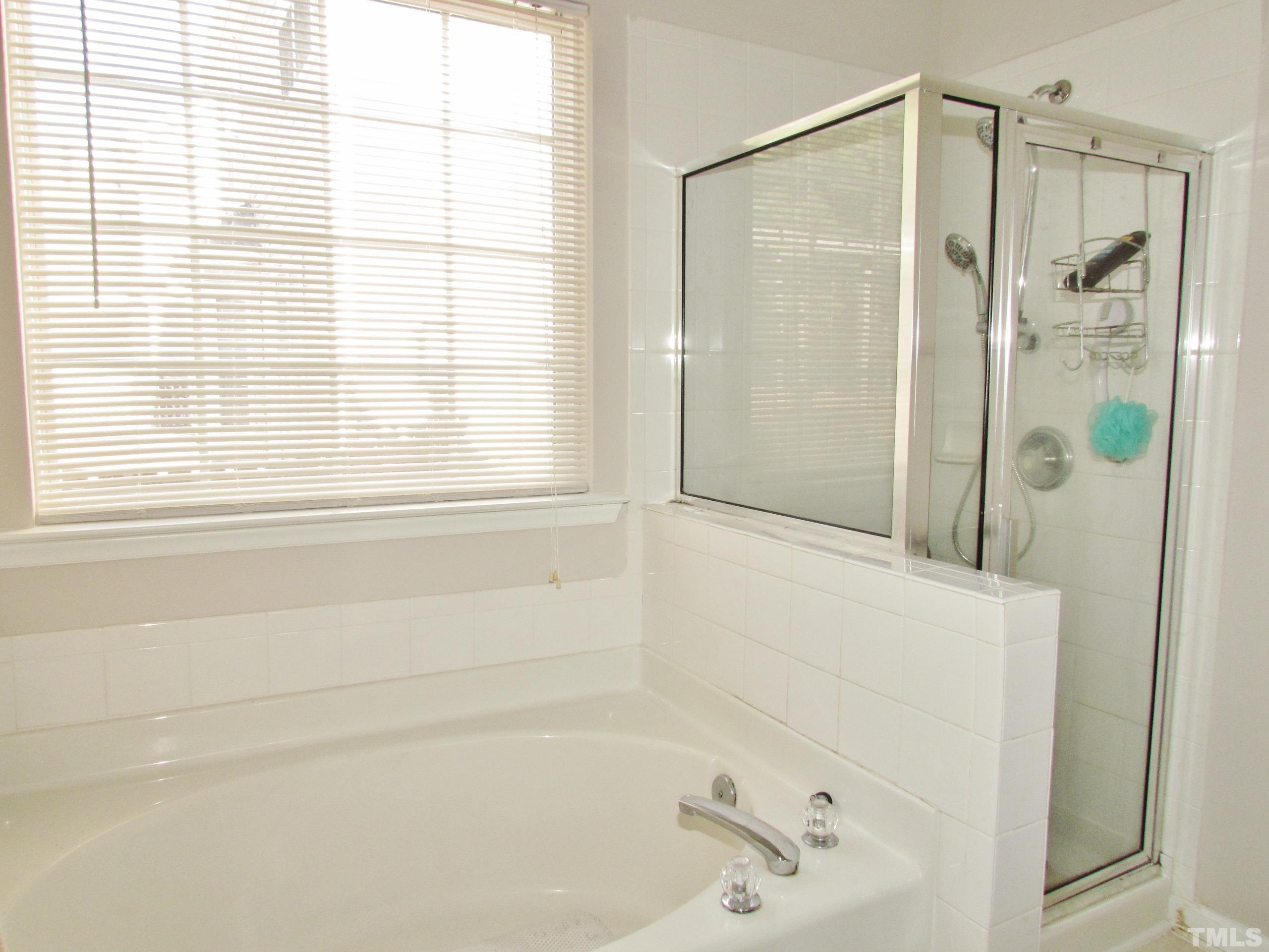 8421 Whisper Ridge Place Raleigh, NC 27613 - Photo 15 of 30 a bathroom with a bathtub and a shower