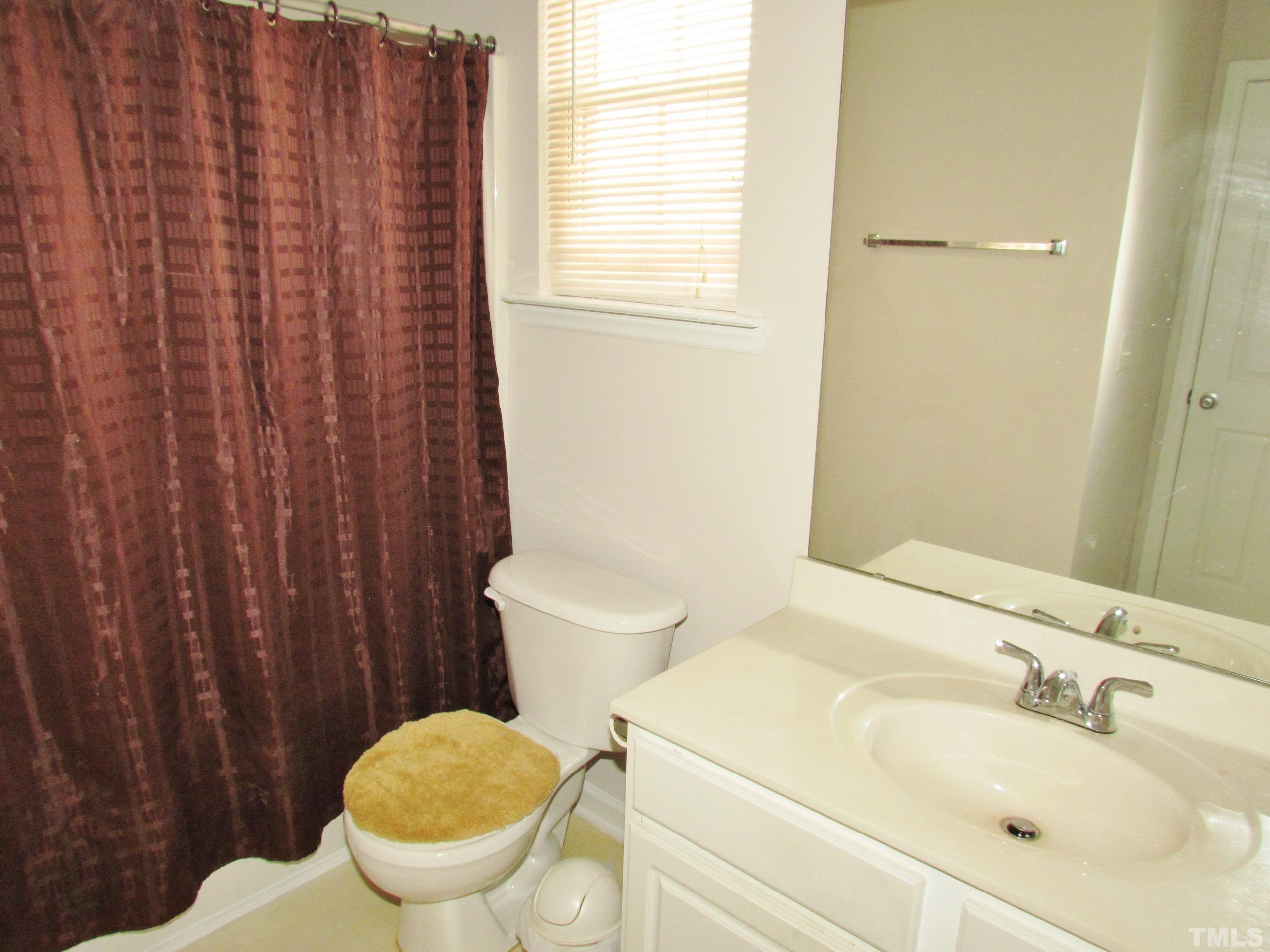 8421 Whisper Ridge Place Raleigh, NC 27613 - Photo 18 of 30 a white toilet sitting next to a bathroom sink
