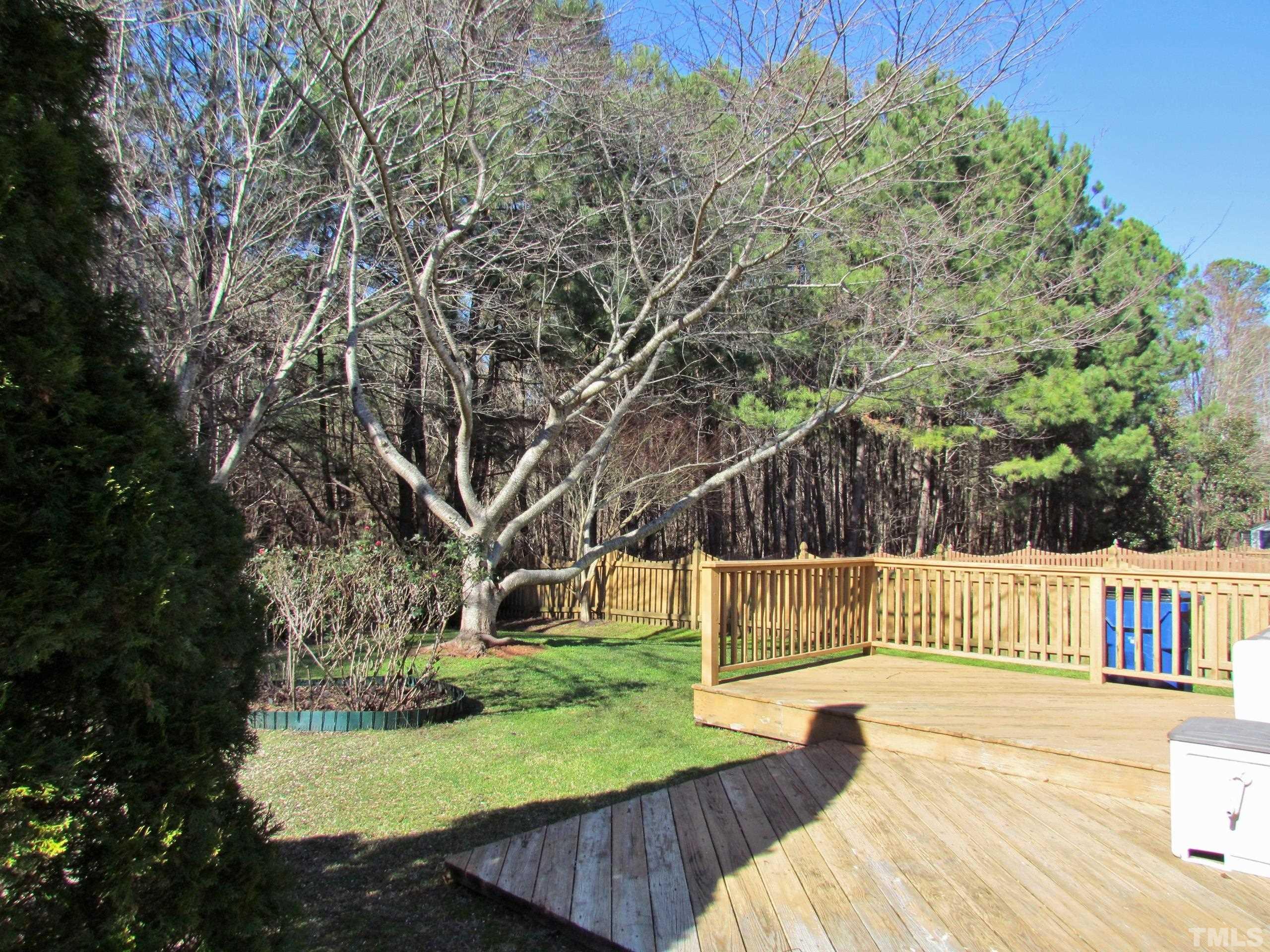 8421 Whisper Ridge Place Raleigh, NC 27613 - Photo 20 of 30 a view of backyard with deck and a garden