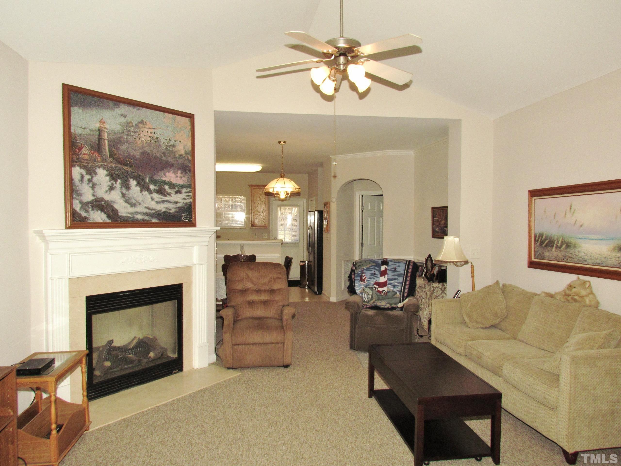 8421 Whisper Ridge Place Raleigh, NC 27613 - Photo 5 of 30 a living room with furniture a fireplace and a flat screen tv