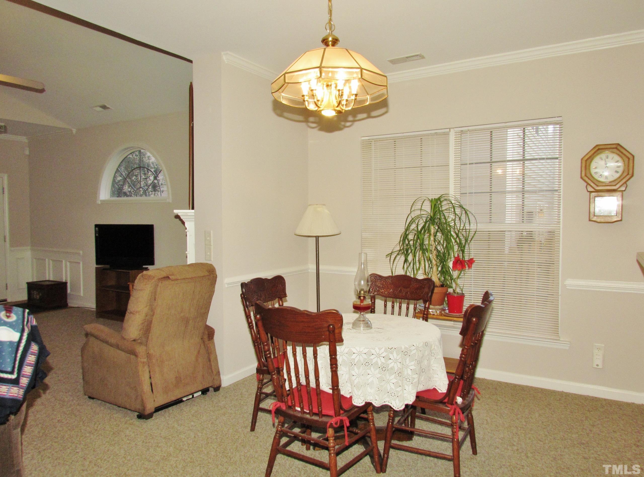 8421 Whisper Ridge Place Raleigh, NC 27613 - Photo 6 of 30 a view of a dining room with furniture and chandelier
