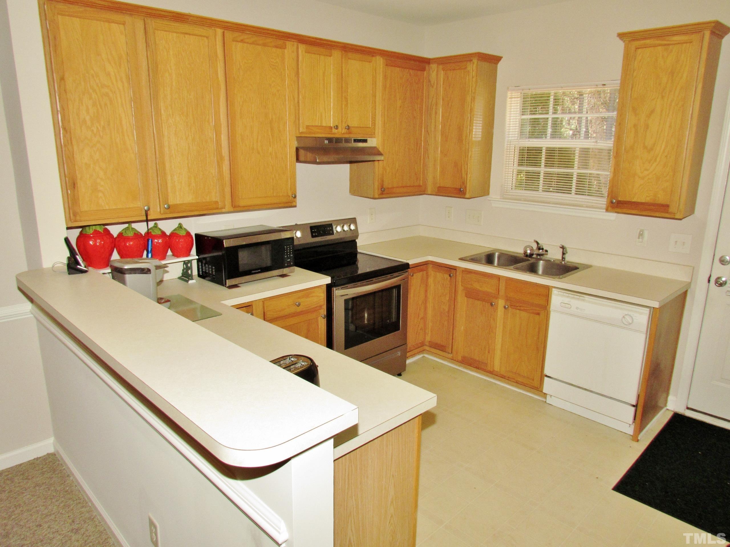 8421 Whisper Ridge Place Raleigh, NC 27613 - Photo 7 of 30 a kitchen with a sink a stove and cabinets