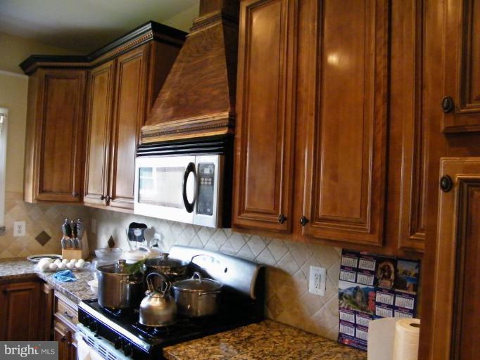 6013 Amherst Avenue Springfield, VA 22150 - Photo 9 of 11 a kitchen with a sink a stove and cabinets