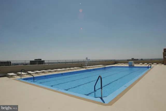 a view of swimming pool with outdoor seating and city view