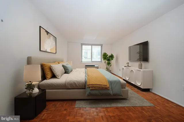 a spacious bedroom with a bed and a flat screen tv