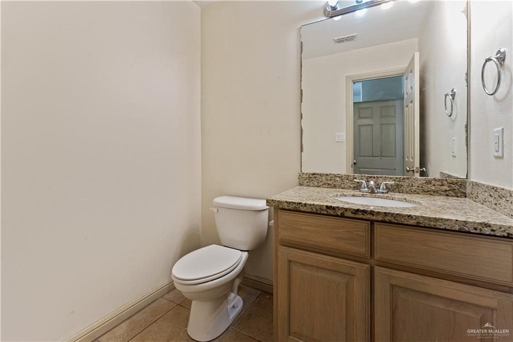 1500 Humming Bird Court, Unit 6 Pharr, TX 78577 - Photo 16 of 26 a bathroom with a granite countertop toilet sink and mirror