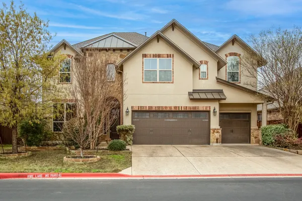 a view of a white house with a yard and large tree