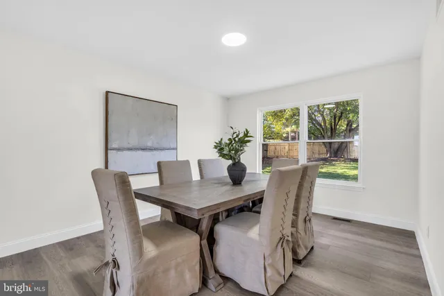 a kitchen with stainless steel appliances a dining table chairs and wooden floor