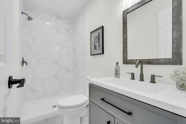 a kitchen with stainless steel appliances a white stove top oven a sink a dining table and chairs