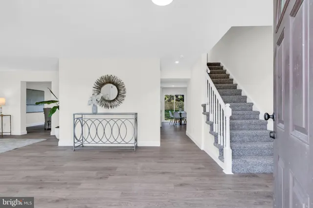 a view of a hallway with wooden floor and stairs