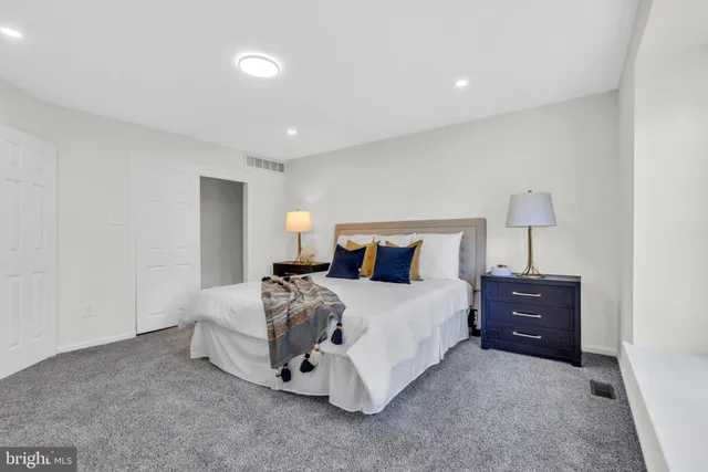 a view of a house with a big yard potted plants and a large tree