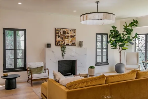 a living room with furniture a chandelier and a flat screen tv