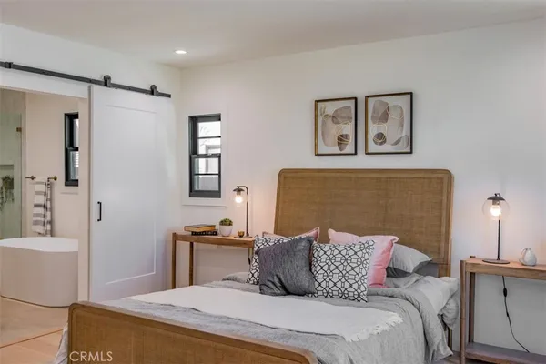 a bedroom with a bed and wooden floor
