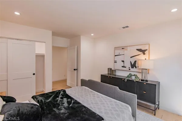 a bedroom with a bed and wooden floor