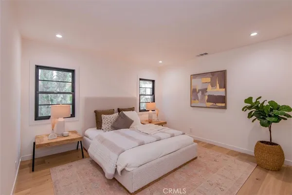 a bedroom with a bed and a potted plant
