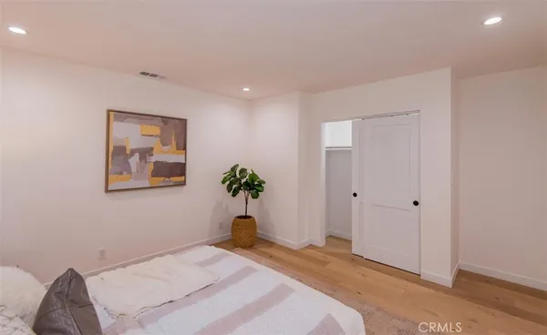 a bedroom with a bed and a painting on the wall