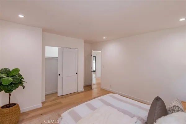 a bedroom with a bed and a potted plant