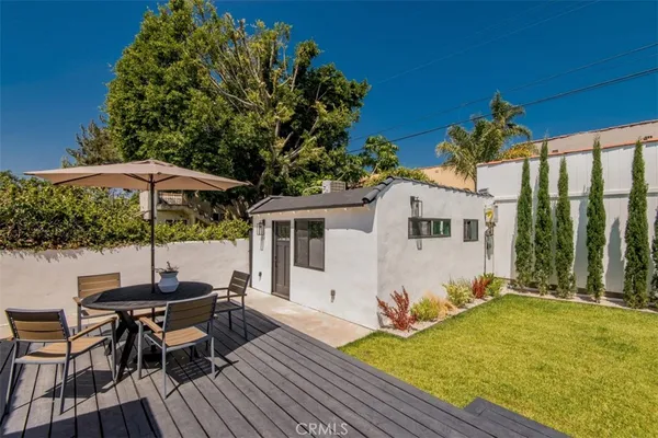 a view of a patio with table and chairs under an umbrella