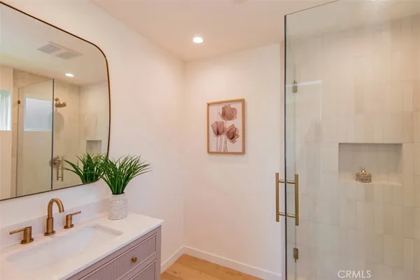 a bathroom with a shower sink vanity and mirror