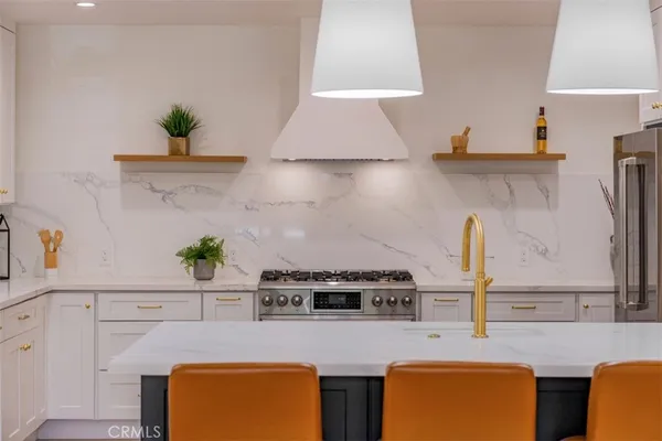 a kitchen with stainless steel appliances granite countertop a stove a sink and a refrigerator