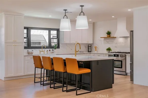 a view of kitchen with granite countertop dining table chairs cabinets and stainless steel appliances