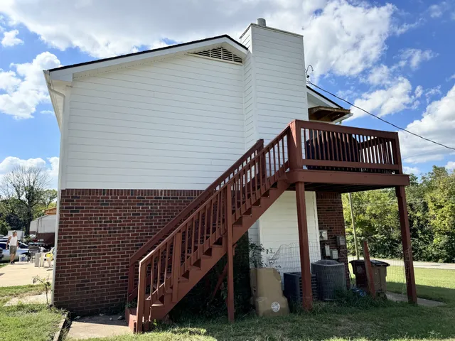 a view of a house with backyard and deck
