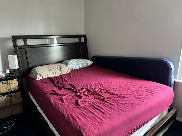 a bedroom with a bed and a lamp with the dresser