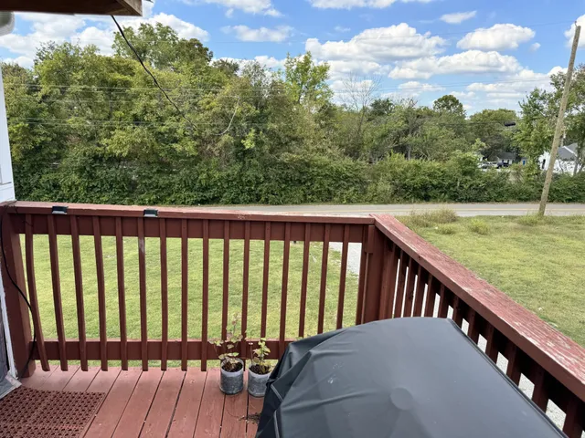 a view of a balcony with wooden floor and fence
