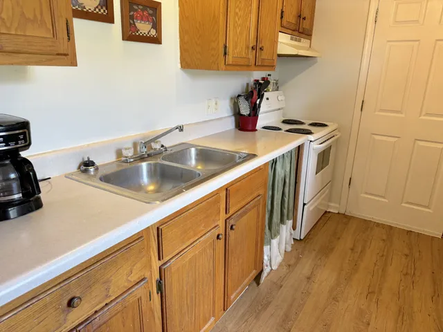 a kitchen with sink a microwave and cabinets