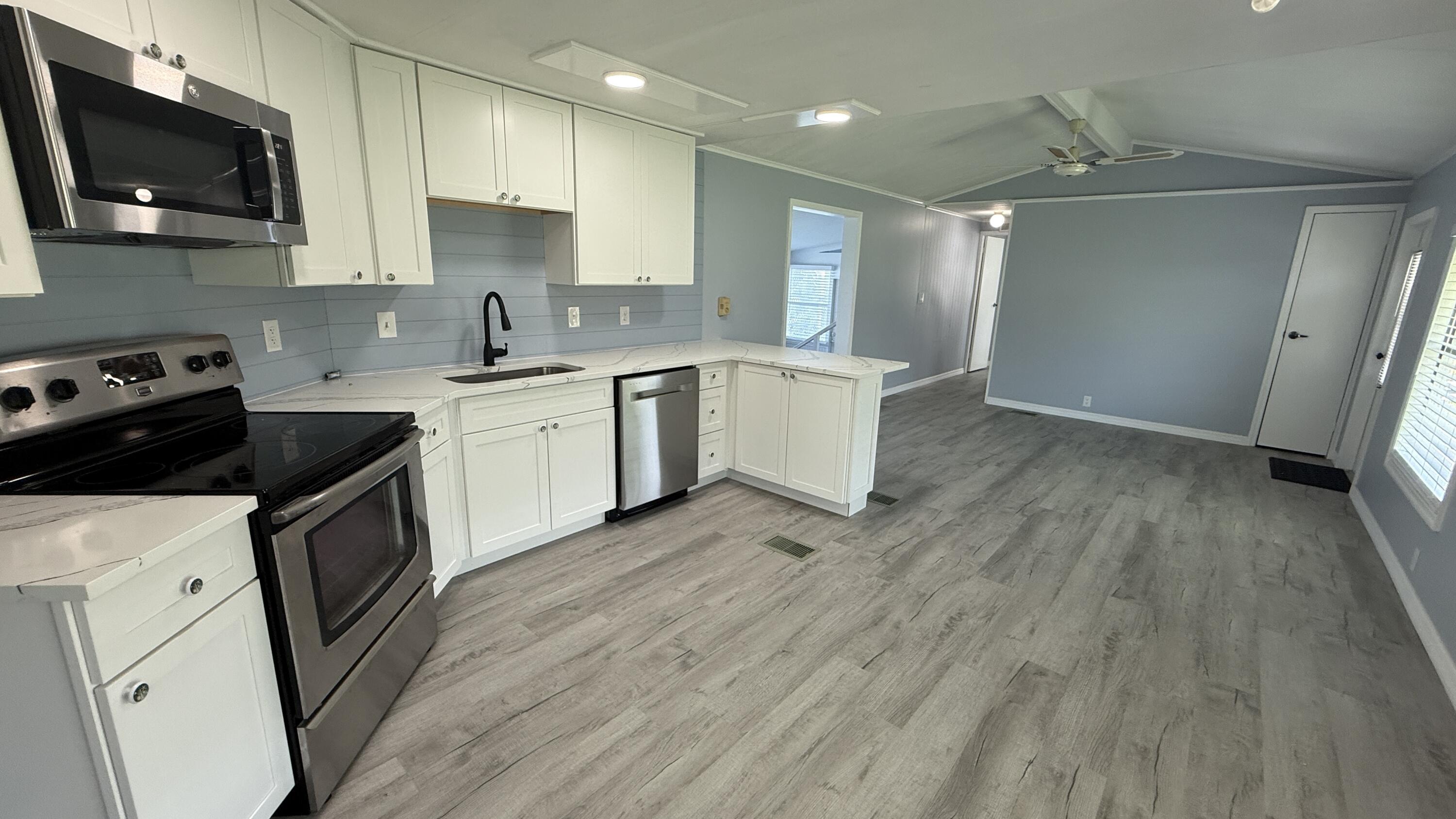 6919 Southeast Congress Street Hobe Sound, FL 33455 - Photo 11 of 52 a kitchen with a sink stove and cabinets