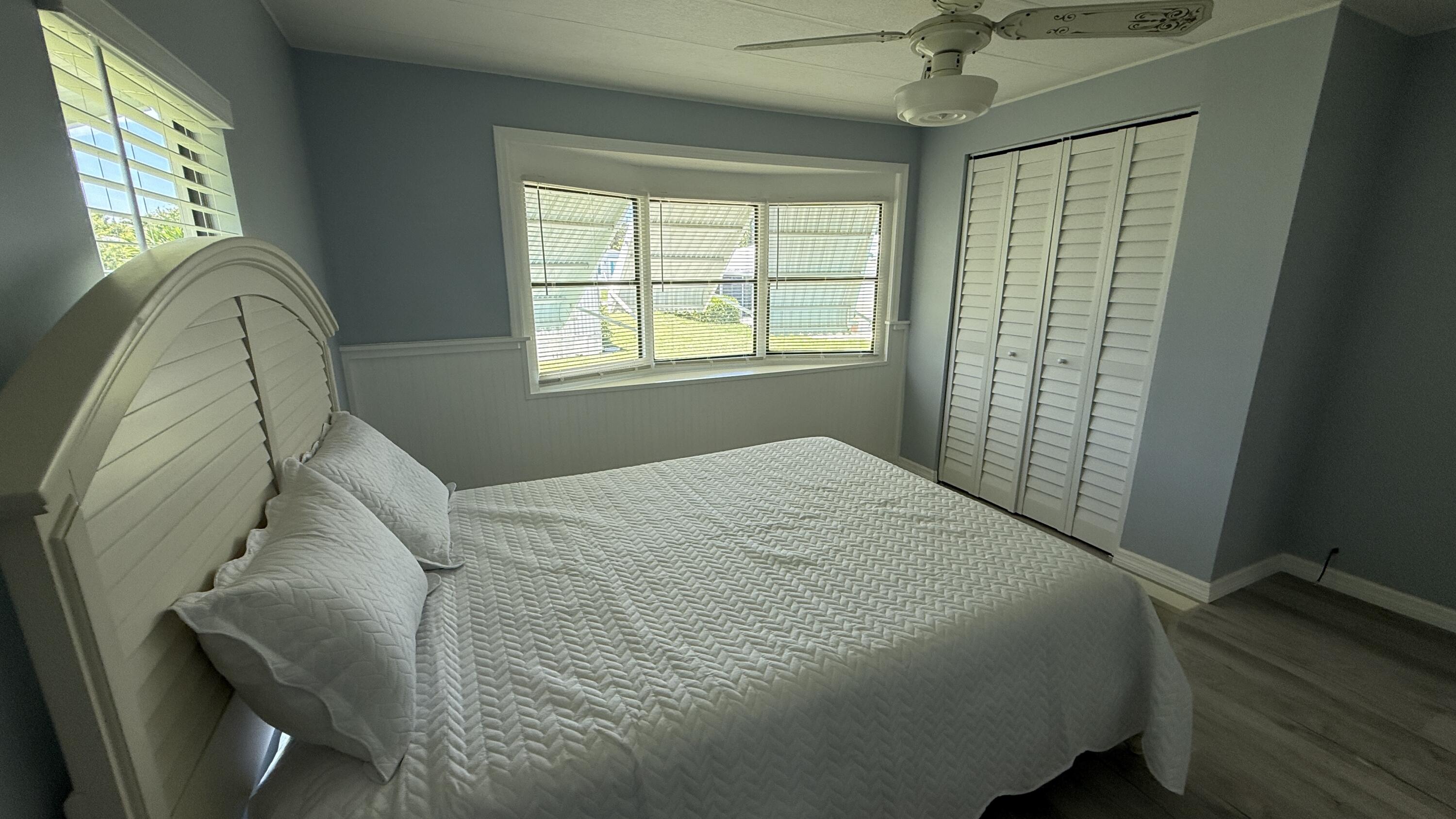 6919 Southeast Congress Street Hobe Sound, FL 33455 - Photo 14 of 52 a bed sitting in a bedroom next to a window