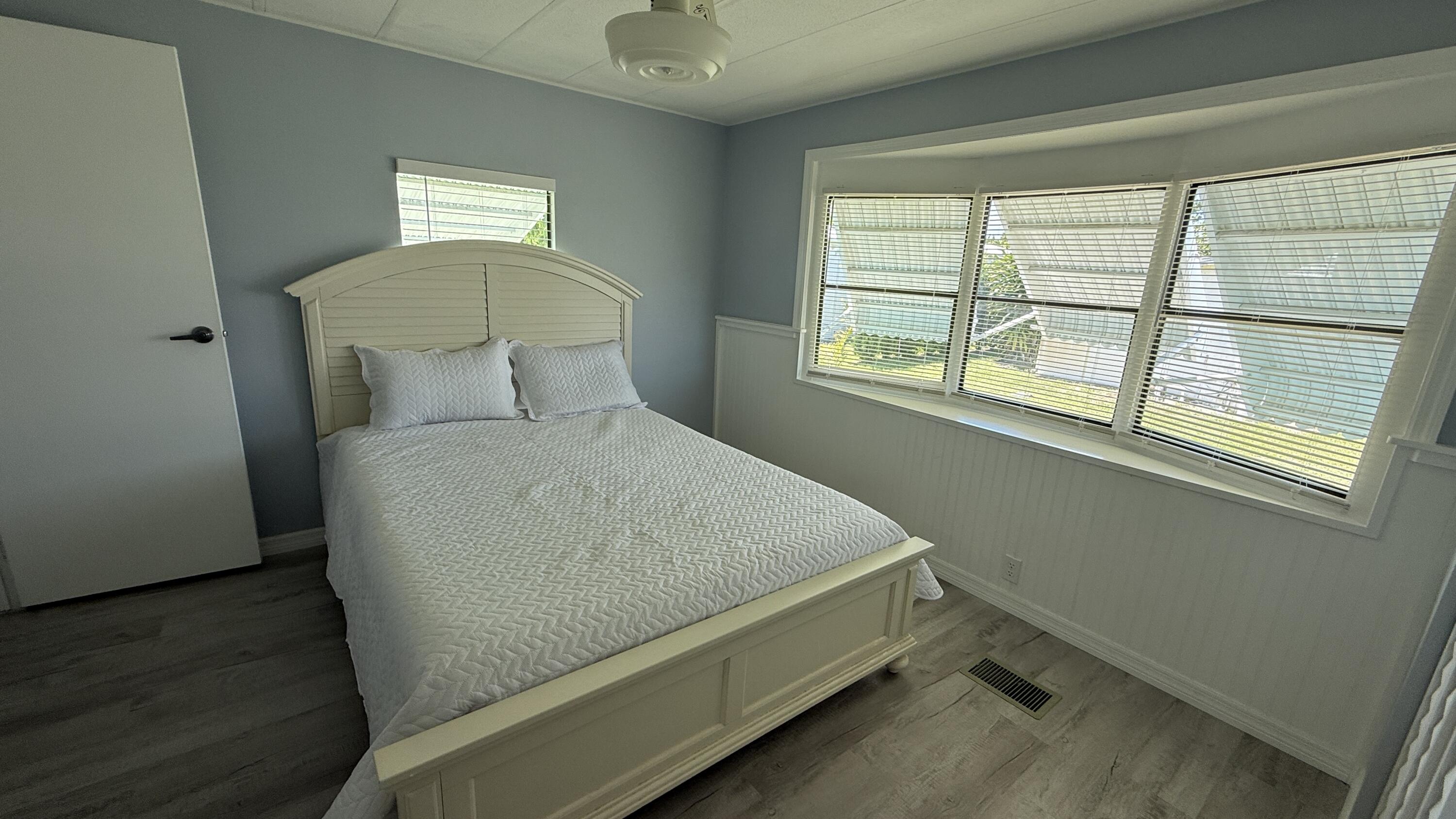6919 Southeast Congress Street Hobe Sound, FL 33455 - Photo 15 of 52 a bed sitting in a bedroom next to a window