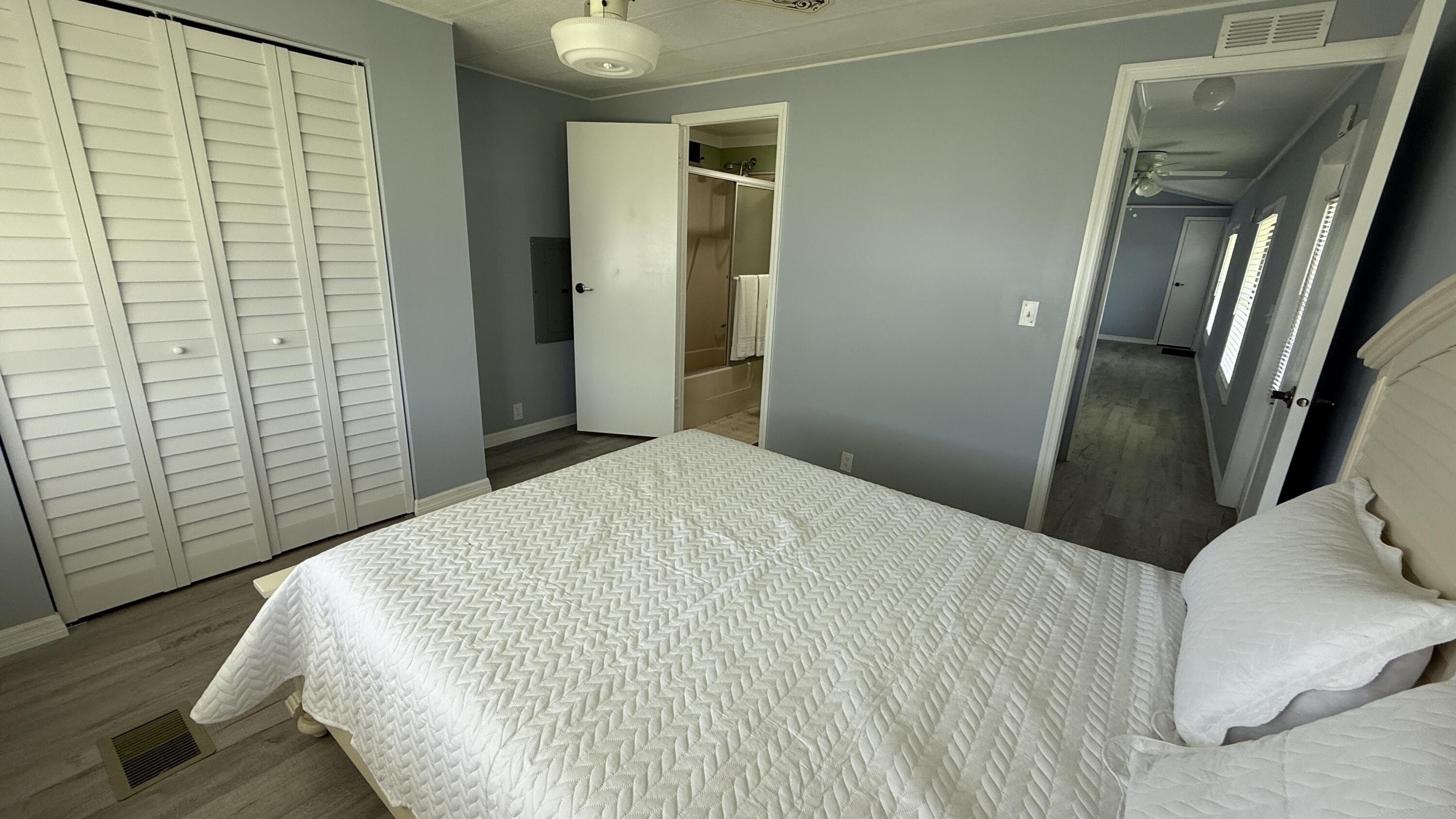 6919 Southeast Congress Street Hobe Sound, FL 33455 - Photo 16 of 52 a bedroom with a bed and wooden floor