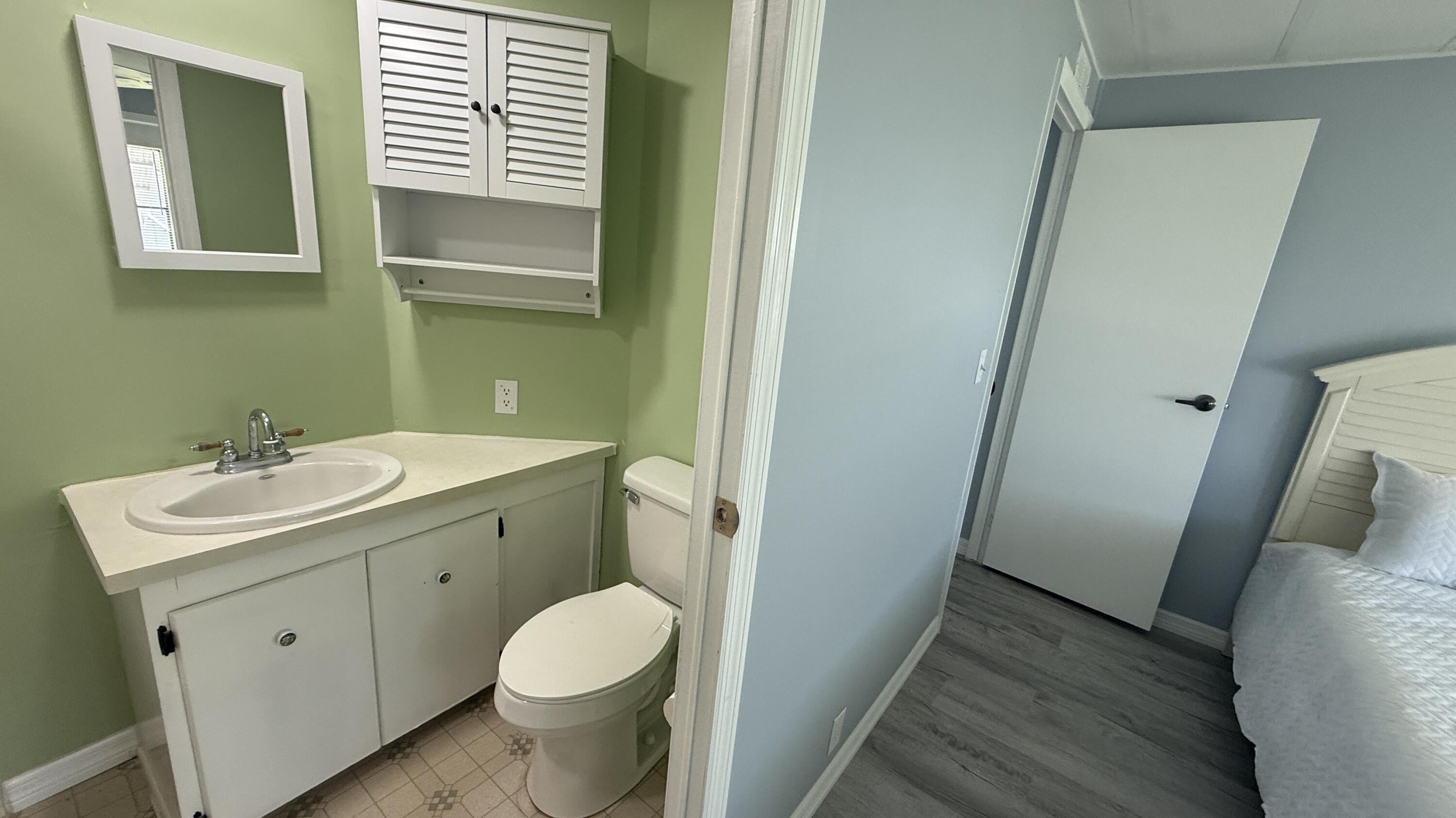 6919 Southeast Congress Street Hobe Sound, FL 33455 - Photo 17 of 52 a bathroom with a sink toilet and vanity