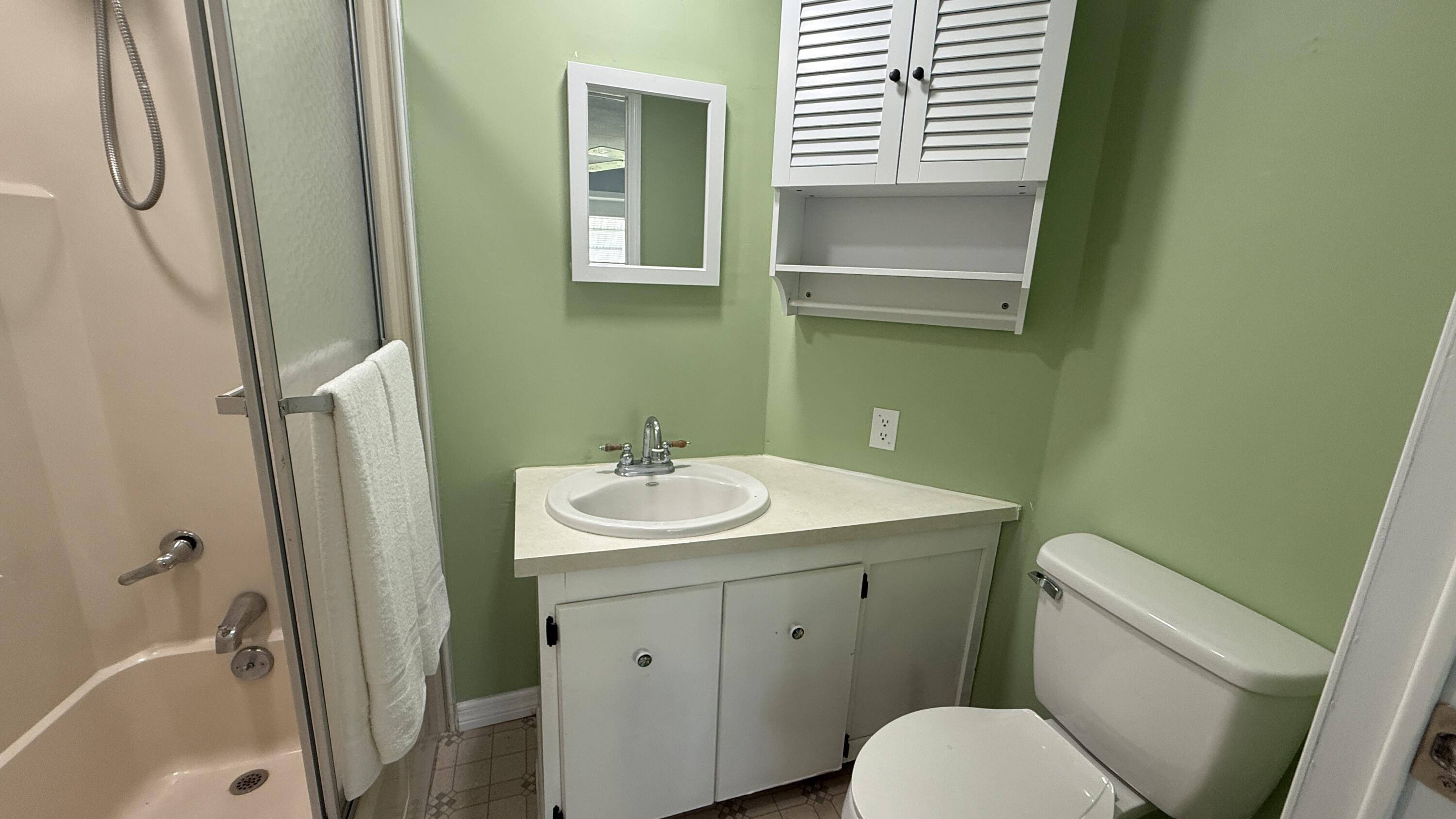 6919 Southeast Congress Street Hobe Sound, FL 33455 - Photo 18 of 52 a bathroom with a sink toilet and tub