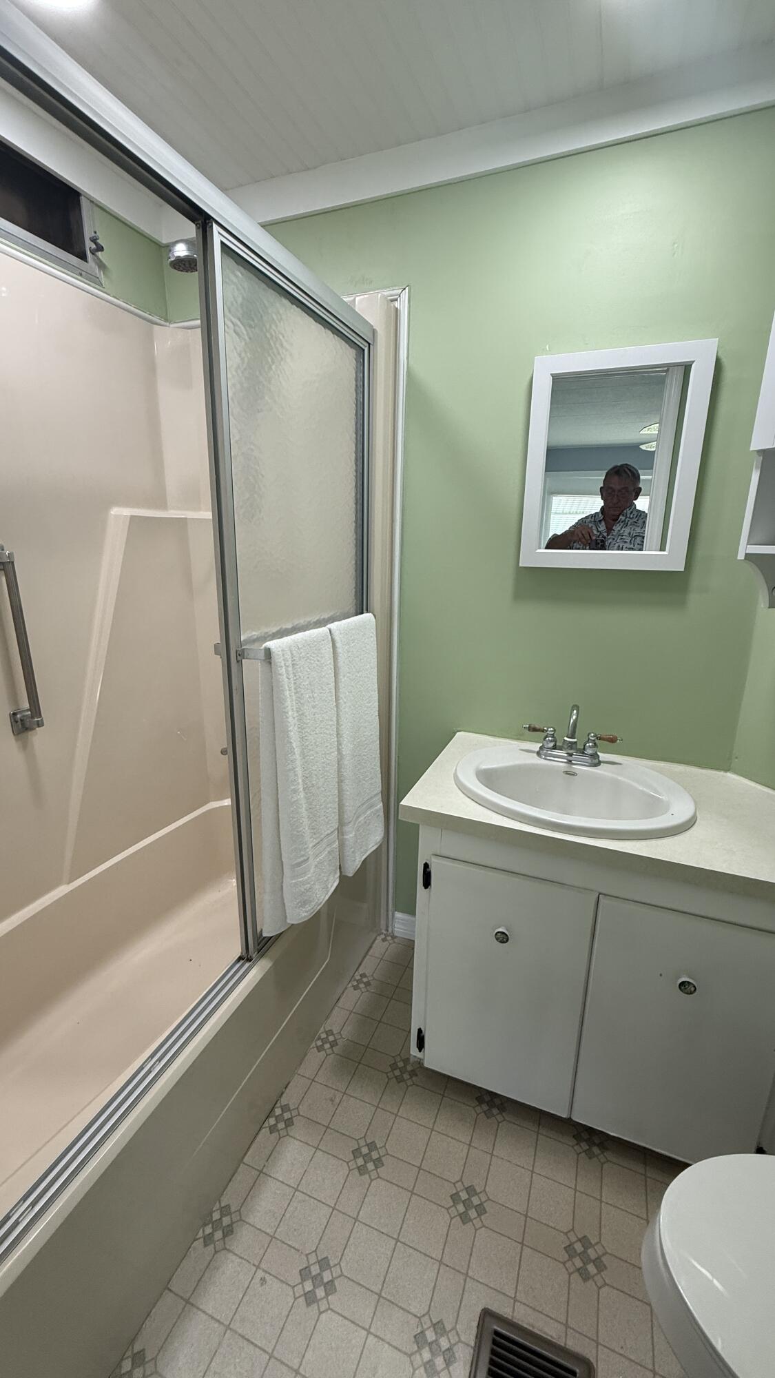 6919 Southeast Congress Street Hobe Sound, FL 33455 - Photo 19 of 52 a bathroom with a sink a mirror and a bathtub