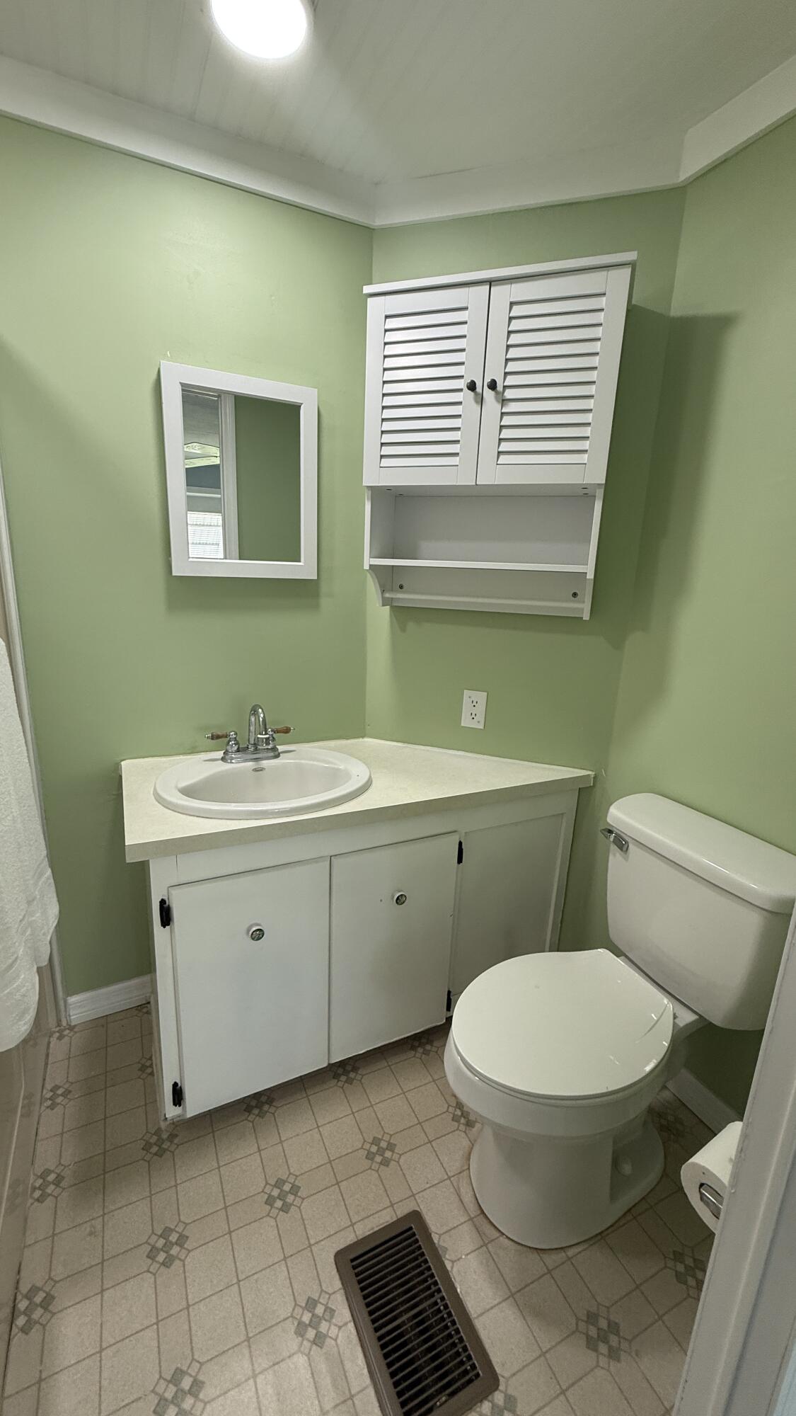 6919 Southeast Congress Street Hobe Sound, FL 33455 - Photo 20 of 52 a bathroom with a toilet sink and mirror