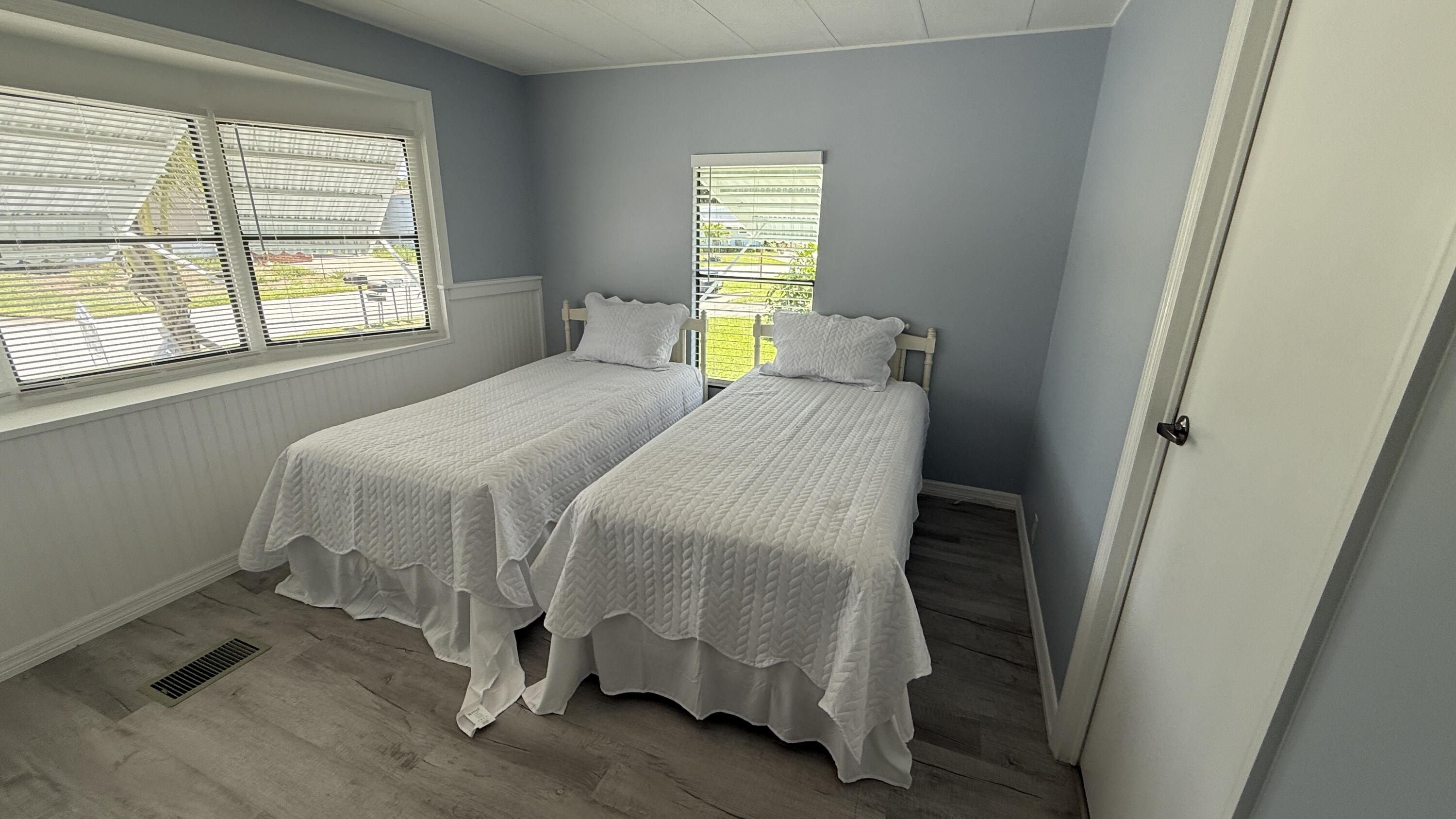 6919 Southeast Congress Street Hobe Sound, FL 33455 - Photo 21 of 52 a bed sitting in a bedroom next to a window