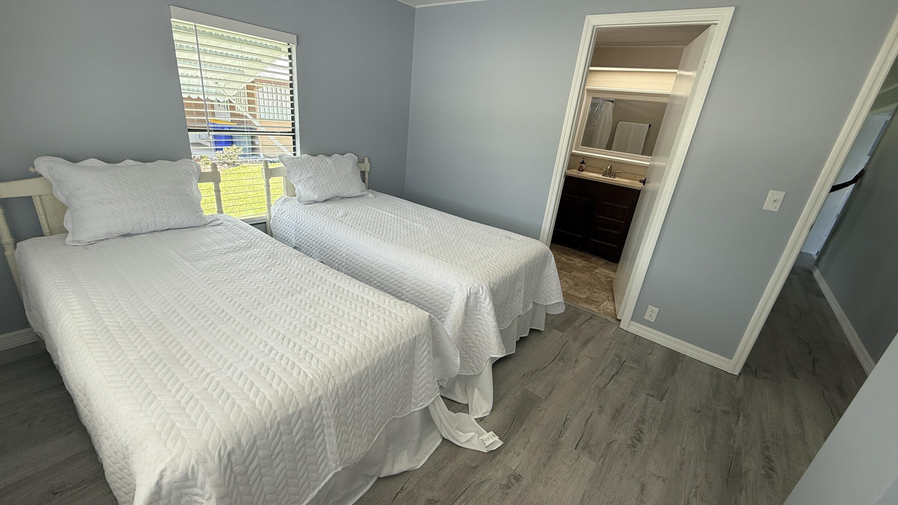 6919 Southeast Congress Street Hobe Sound, FL 33455 - Photo 22 of 52 a bedroom with two beds and a window