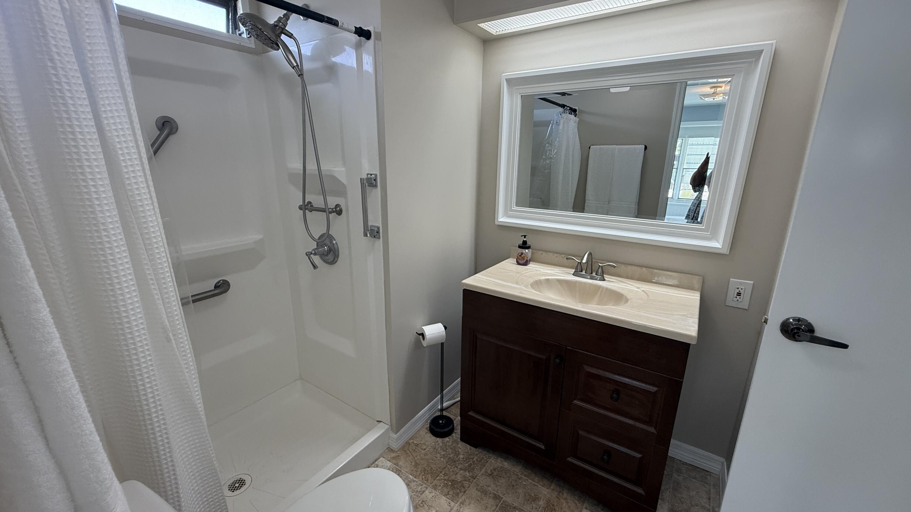 6919 Southeast Congress Street Hobe Sound, FL 33455 - Photo 25 of 52 a bathroom with a sink vanity granite shower and a mirror