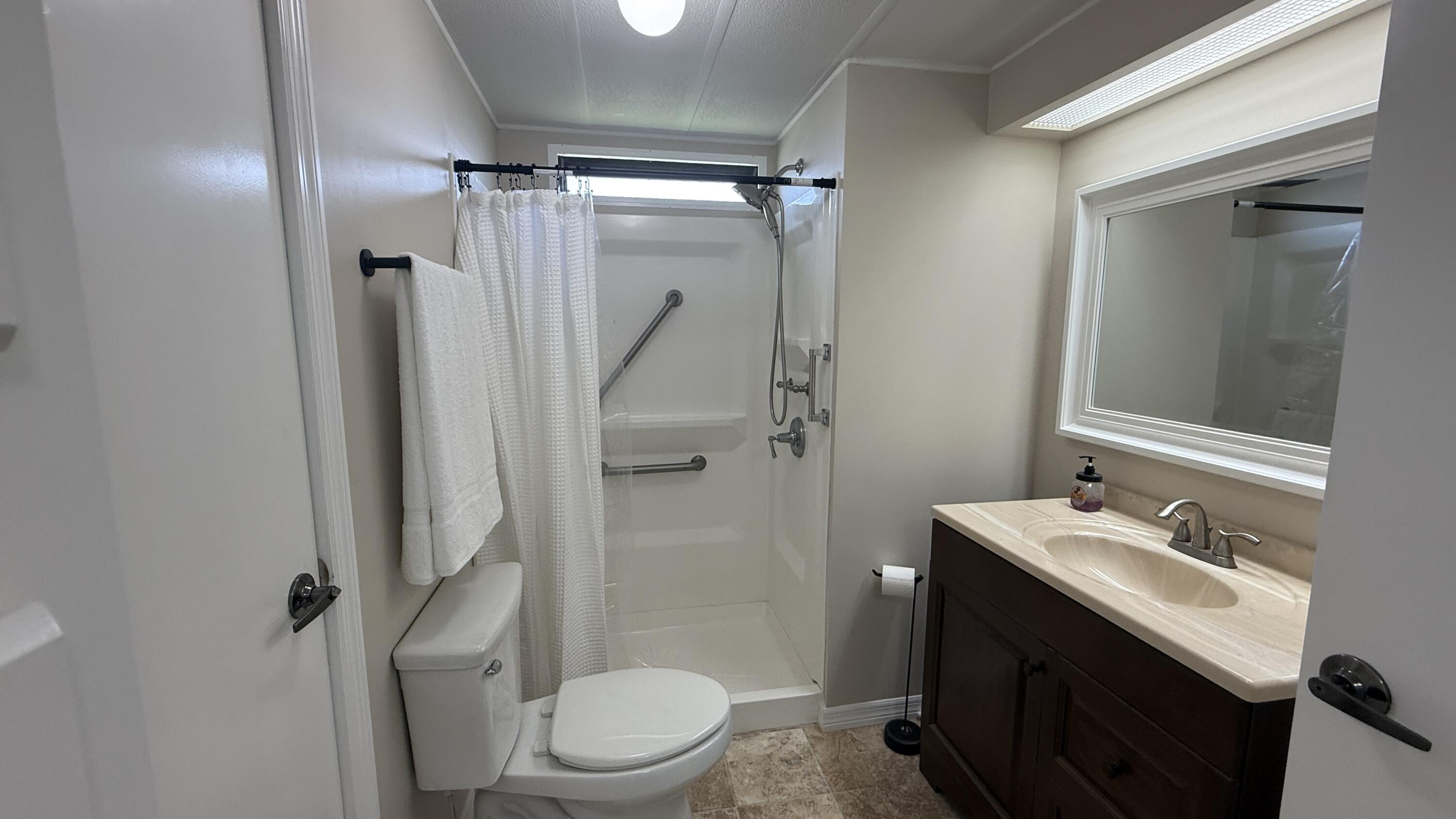 6919 Southeast Congress Street Hobe Sound, FL 33455 - Photo 26 of 52 a bathroom with a granite countertop sink toilet and shower