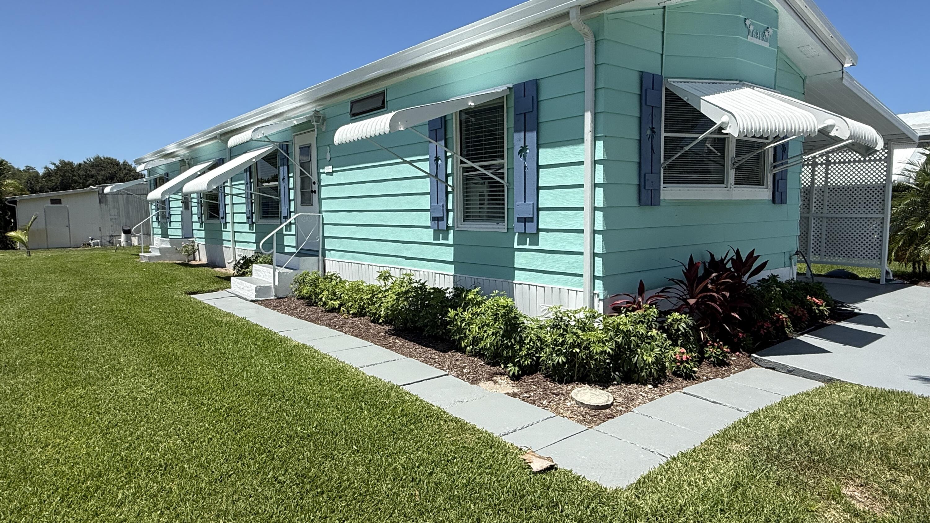 6919 Southeast Congress Street Hobe Sound, FL 33455 - Photo 35 of 52 a front view of a house with a yard