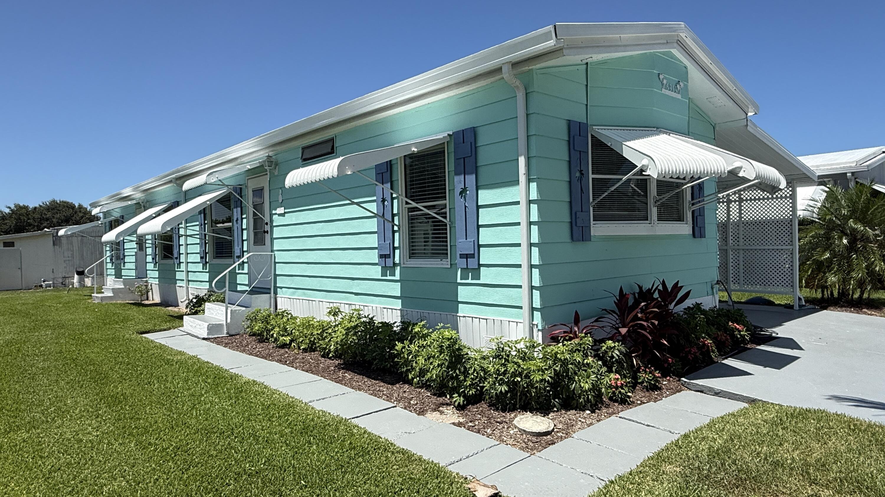 6919 Southeast Congress Street Hobe Sound, FL 33455 - Photo 36 of 52 a front view of a house with garden