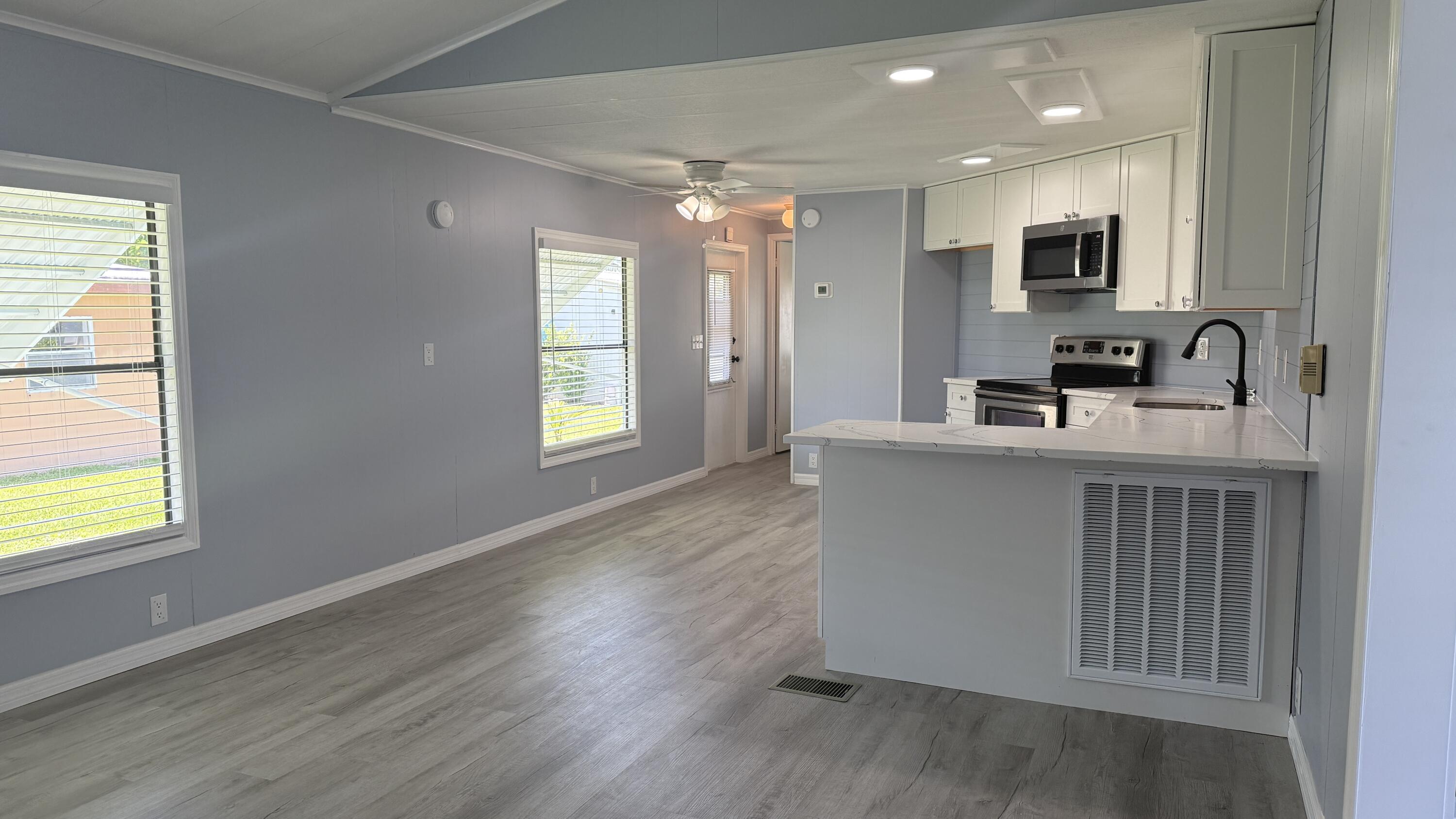 6919 Southeast Congress Street Hobe Sound, FL 33455 - Photo 8 of 52 a kitchen with kitchen island granite countertop a sink appliances and cabinets