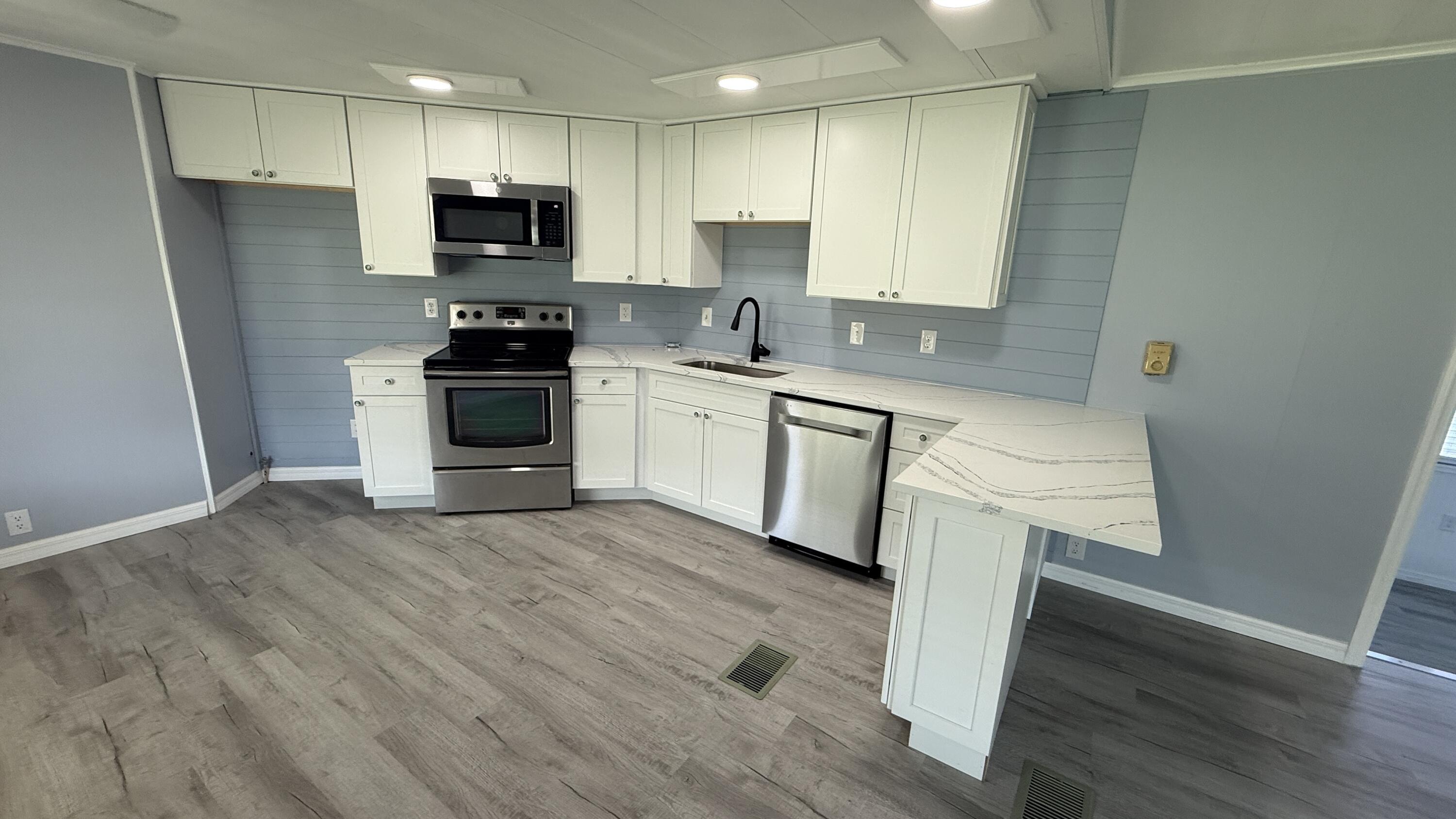 6919 Southeast Congress Street Hobe Sound, FL 33455 - Photo 9 of 52 a kitchen with a sink a microwave a stove and refrigerator