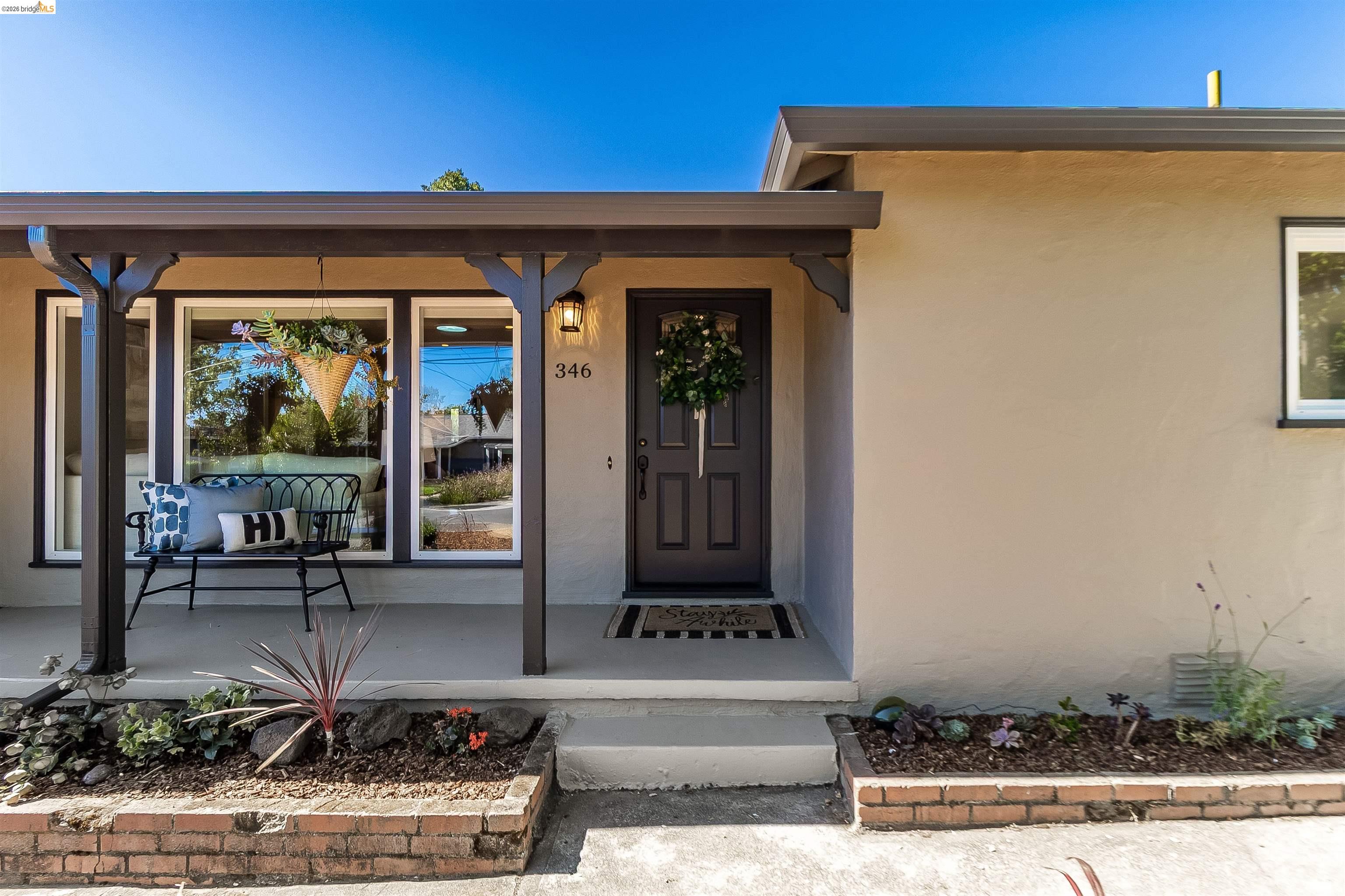 346 Valley View Road Pleasant Hill, CA 94523 - Photo 4 of 57 Front exterior featuring a covered porch with dark wood columns and beams, stucco siding, and a dark paneled entry door